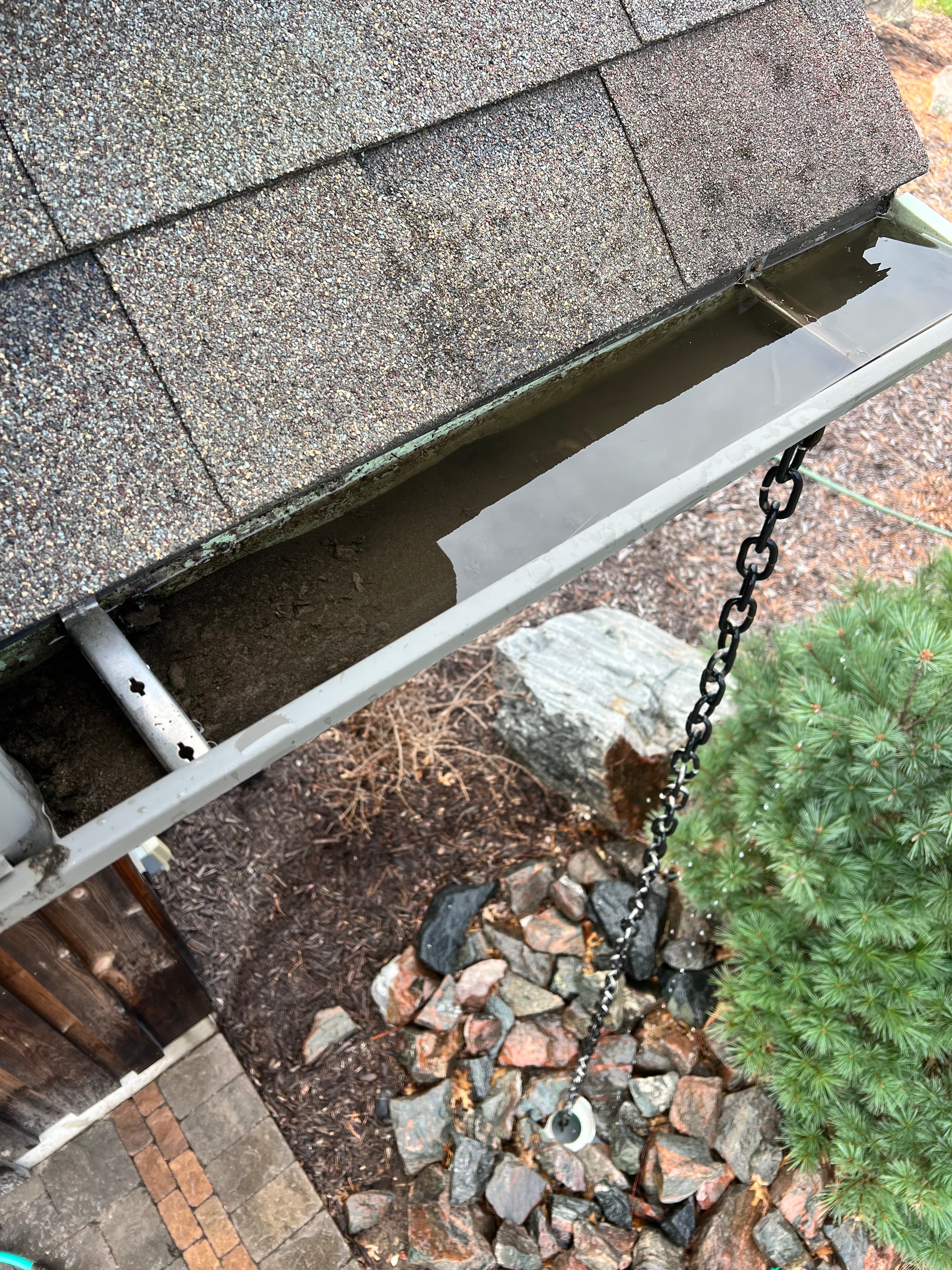 Gutter before cleaning with visible debris and blockage