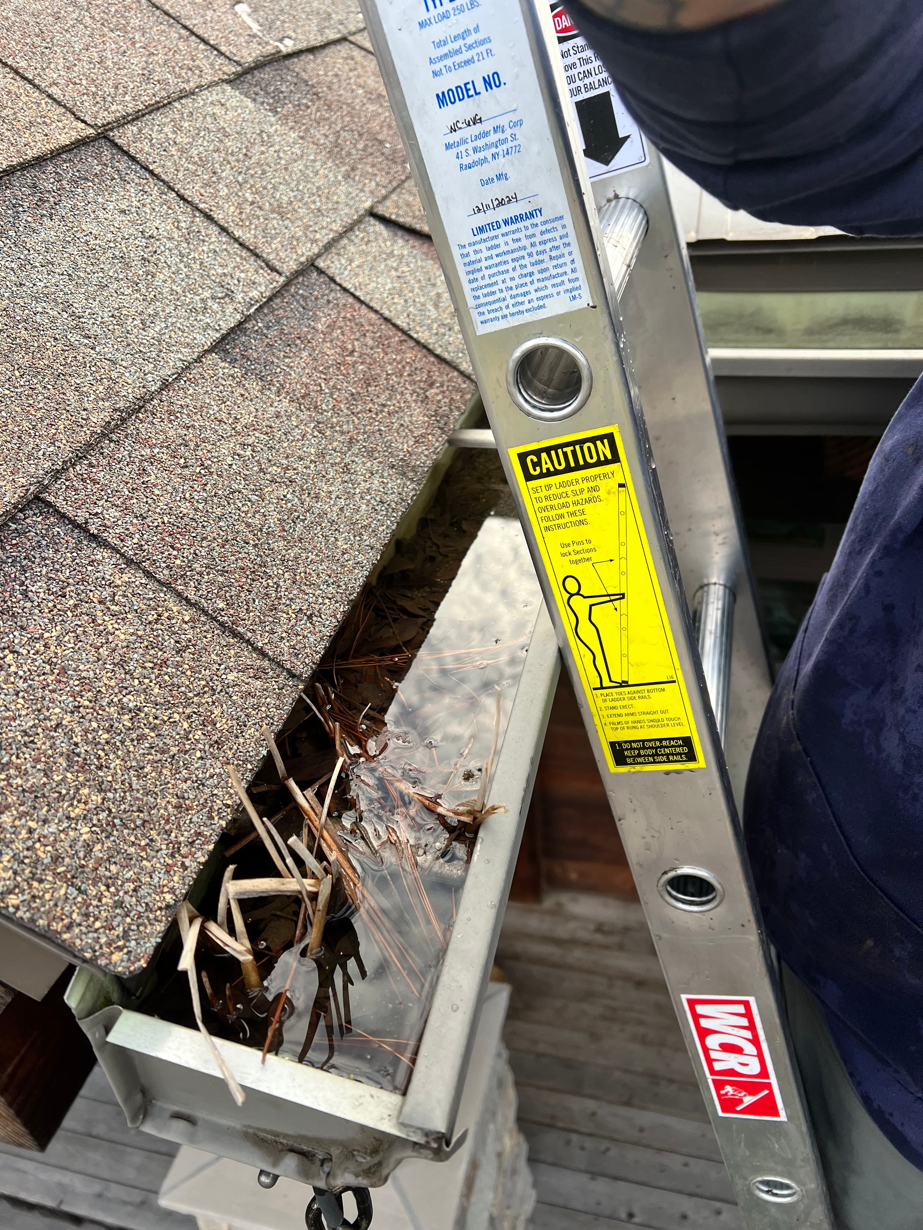 Gutter before cleaning with heavy debris buildup