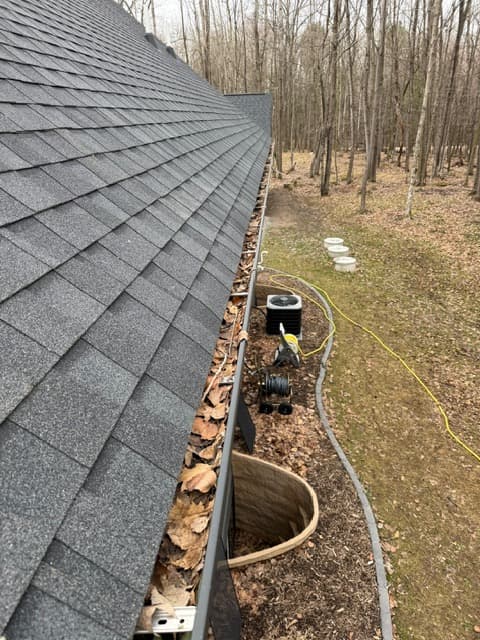 Gutter before cleaning with debris from the new gutter set